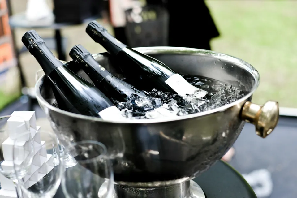 Seau à champagne rempli de glaçons et de bouteilles lors d’une réception